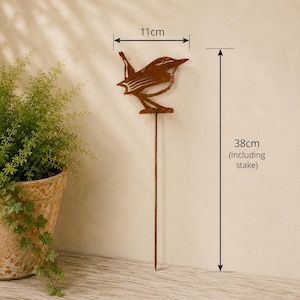 May include: A rust-colored metal bird garden stake featuring a cutout silhouette design. The bird figure measures 11 cm in width, and the total height of the garden stake, including the thin metal rod, is 38 cm as indicated by the labels.