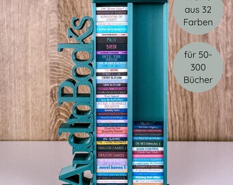 May include: A teal-colored bookshelf with the word "Audiobooks" on the side. The bookshelf holds numerous books with colorful spines. Text on the right says "Choose from 32 colors" and "for 50-300 books."