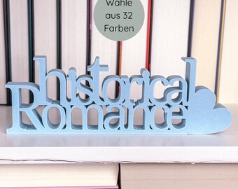 May include: A light blue, freestanding sign that reads "historical romance" in a decorative font. The sign is placed in front of a stack of books. A circular graphic above the sign says "Wähle aus 32 Farben".