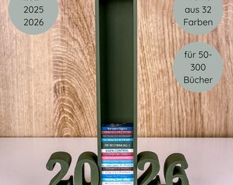 Könnte beinhalten: Ein dunkelgrünes Bücherregal mit den Zahlen 2026 an der Basis. Das Bücherregal enthält einen Stapel bunter Bücher. Der Text auf dem Bild lautet: "2024, 2025, 2026", "Wählen Sie aus 32 Farben" und "für 50-300 Bücher."