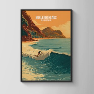 Könnte beinhalten: Gerahmter Kunstdruck mit einem Surfer auf einer Welle in Burleigh Heads, Queensland, Australien. Das Kunstwerk ist im Stil eines Vintage-Reiseposters gehalten, mit Orange-, Türkis- und Brauntönen. Der Text "BURLEIGH HEADS QLD, AUSTRALIA" befindet sich oben.
