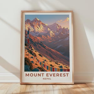 May include: A framed vertical art print featuring a landscape illustration of Mount Everest in Nepal. The scene depicts snow-capped mountain peaks under a soft sky, with colorful prayer flags strung across the foreground slopes in warm tones.