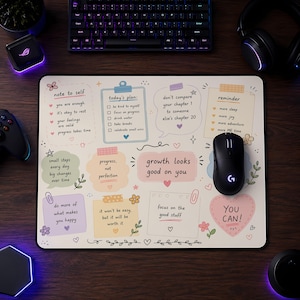 May include: A rectangular desk mat featuring a cream-colored background with various pastel-colored sticky notes, speech bubbles, and checklists containing motivational text such as 'growth looks good on you' and 'today's plan' with small floral and heart illustrations.