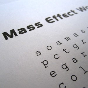 May include: A printed word search puzzle titled "Mass Effect Word Search" in black font on white paper. The puzzle includes the words "soamassre", "pctgrco", "egarrru", and "collie".
