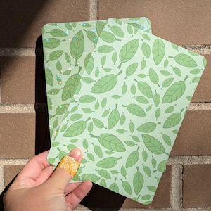 May include: Two cards with a green leaf pattern. One card has a glittery finish.