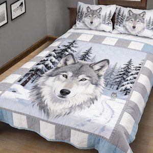 May include: A quilted bedspread and two pillowcases featuring a wolf design. The bedspread has a large wolf portrait in a snowy forest scene, with a smaller wolf in the background. The pillowcases have a wolf portrait and pine trees.