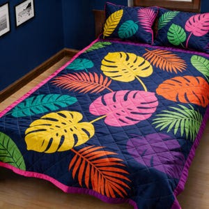 May include: A navy blue quilt and two pillow set with a vibrant tropical leaf pattern. The leaves are in shades of yellow, pink, orange, green, and purple. The quilt has a pink border and a diamond stitch pattern.
