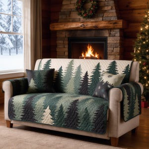 May include: A beige sofa with a forest-themed quilt and matching throw pillows. The quilt features a pattern of green and black pine trees. The scene includes a fireplace, Christmas tree, and a snowy window.