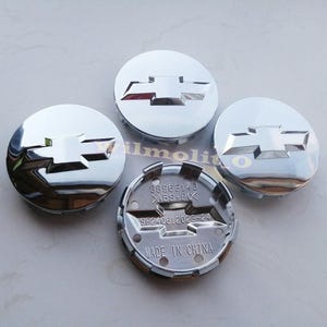 May include: Set of four silver car hubcaps with a Chevrolet logo and the text "88963143 >ABS+PC< SF240612023-24 MADE IN CHINA".