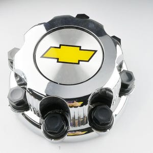 May include: Chrome wheel cover with a yellow Chevrolet logo in the center. The cover has six black plastic lug nut covers.