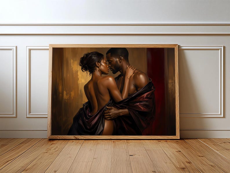 May include: A framed horizontal wall art print depicting a couple in an intimate embrace. The figures are draped in dark, flowing fabric against a warm, golden-brown and deep red background, highlighting their skin tones and close connection.