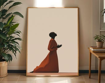 Könnte beinhalten: Ein gerahmter Kunstdruck mit der Silhouette einer dunkelhäutigen Person mit kahlgeschorenem Kopf, die im Profil kniet und die Hände zum Gebet gefaltet hat. Die Figur trägt ein langes, fließendes rostfarbenes Kleid vor einem cremefarbenen Hintergrund.