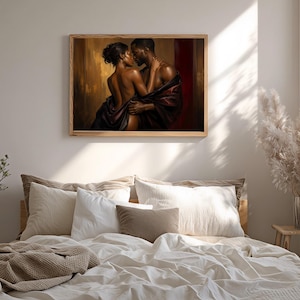May include: A framed wall art print depicting a couple in an intimate embrace, draped in dark fabric against a warm, golden-brown and deep red background. The artwork features rich lighting and shadows, highlighting the figures in a close pose.