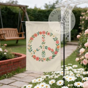 May include: A cream-colored garden flag featuring a central peace sign composed of various colorful flowers and green leaves. The floral arrangement includes pink roses, orange tulips, and white lilies. The text NATTHATSHOP MY STORE is visible.