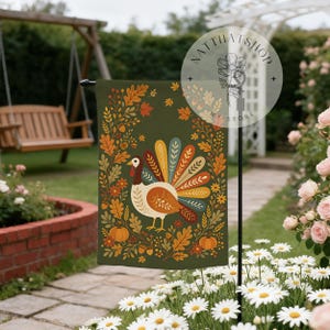 Könnte beinhalten: Eine rechteckige Gartenflagge mit dunkelolivgrünem Hintergrund, die in der Mitte einen Truthahn zeigt, umgeben von einem Kranz aus Herbstblättern, Eicheln und Kürbissen. Der Truthahn hat einen bunten, gemusterten Schwanz in Gelb-, Orange- und Blautönen.