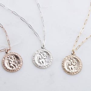 May include: Three gold, silver, and rose gold necklaces with a round pendant featuring a detailed image of a person holding a child. The pendants are all the same size and design, but in different metal finishes.