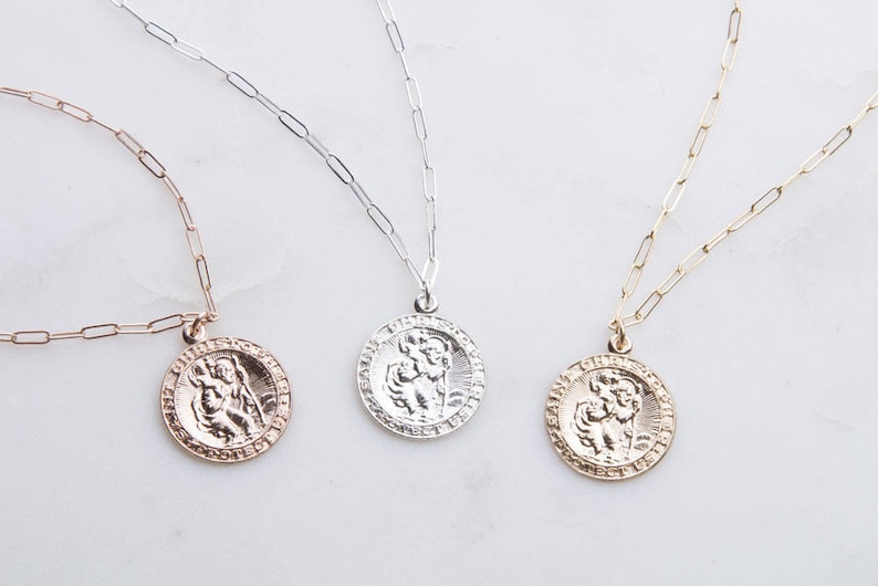 May include: Three gold, silver, and rose gold necklaces with a round pendant featuring a detailed image of a person holding a child. The pendants are all the same size and design, but in different metal finishes.