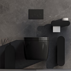 Puede incluir: Un inodoro suspendido de color negro mate con una placa de descarga rectangular a juego, un portarrollos negro con papel blanco, un soporte vertical negro para accesorios y un difusor de varillas negro sobre una pared de mármol gris oscuro.
