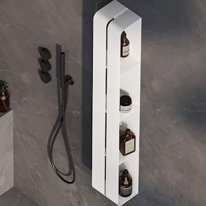 以下が含まれることがあります： 4段の棚が付いた白い壁掛けシャワー棚。茶色のバス製品のボトルが入っています。黒いシャワーヘッドと蛇口が灰色のタイルの壁に取り付けられています。棚はモダンでミニマリストなデザインです。