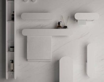 May include: A collection of white bathroom accessories including a tall vertical shelving unit, a wall-mounted towel rack with a white towel, a toilet paper holder, two small wall hooks, a floor-standing waste bin, and a vertical storage unit.