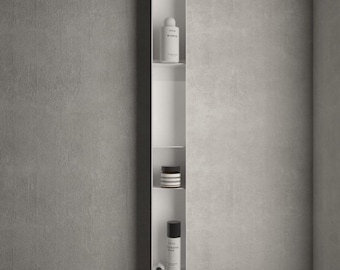 May include: A tall, narrow, white vertical wall-mounted shelf unit featuring multiple open compartments. The shelves hold various cylindrical containers, including bottles and a small jar. A single hook at the bottom supports a hanging wooden brush.