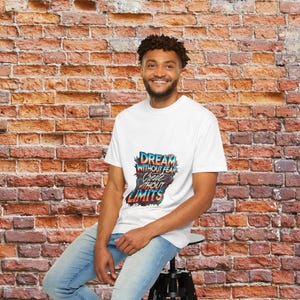 Peut inclure: Un t-shirt blanc avec un imprimé graphique coloré qui dit "Dream without fear, Create without limits".