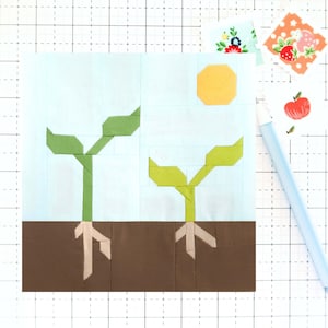 May include: Two green plants with brown roots growing in brown soil. A yellow sun is in the blue sky above the plants.