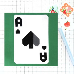Könnte beinhalten: Eine weiße Spielkarte mit grünem Rand. Die Karte ist ein Ass Pik. Die Farbe ist schwarz und grau.