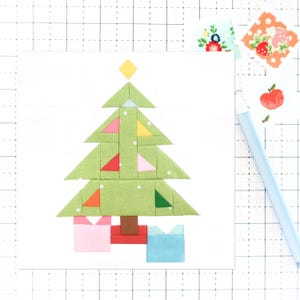 May include: A green patchwork Christmas tree with a yellow star on top. The tree is decorated with red, orange, yellow, blue, and pink triangles. The tree is sitting on a red and brown base with two pink and blue boxes.