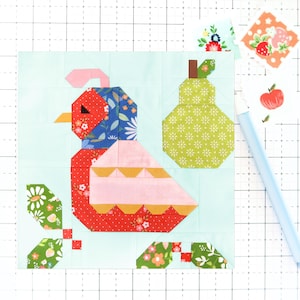 May include: A patchwork quilt block featuring a red, pink and yellow bird with a blue head, a green pear and green leaves on a light blue background.