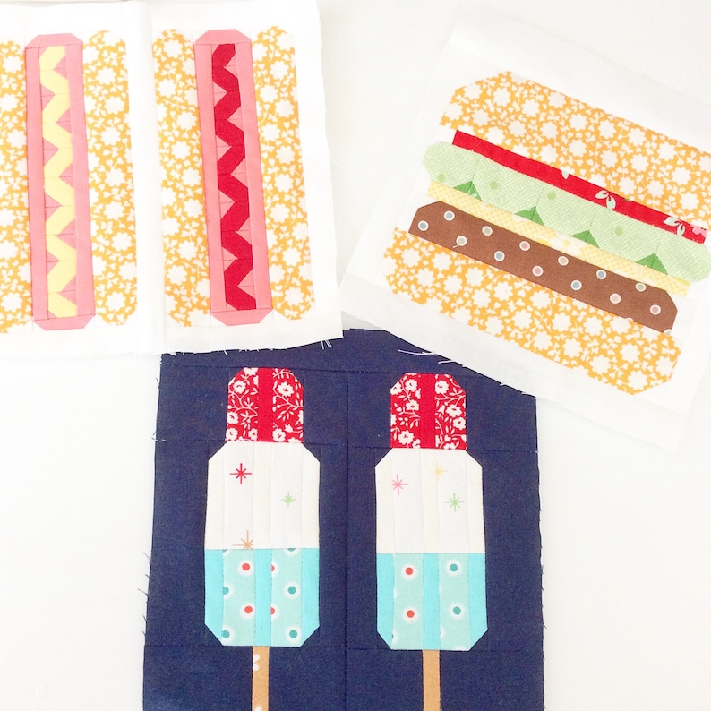 May include: A set of fabric squares featuring various summer food designs. The squares are made of different patterned fabrics and include a hot dog, hamburger, and popsicles.