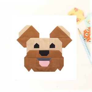 May include: A brown and tan geometric dog block pattern with a pink tongue. This is a digital pattern for a quilt block.