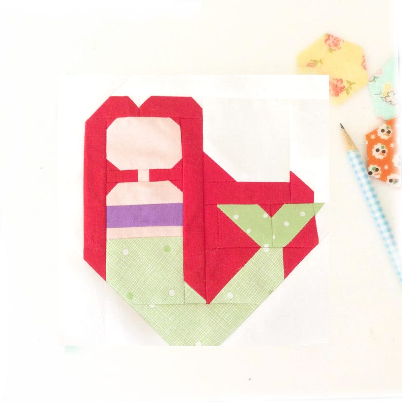 May include: A red, green, and pink fabric applique of a mermaid with a green tail and a purple and pink bodice.