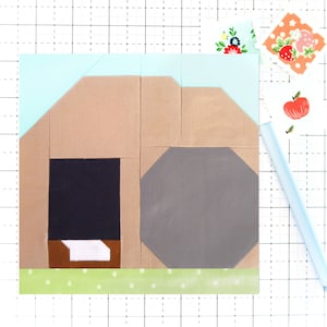 May include: A brown and tan house with a black door and a grey octagonal window. The house is on a green background with white polka dots.