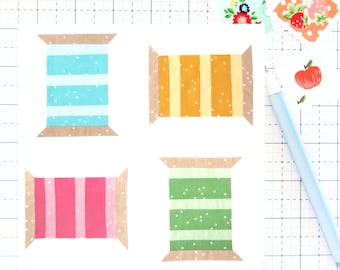 May include: Four fabric spools with different patterns. The spools are brown with white stripes and feature a variety of patterns including blue and white stripes, yellow and white stripes, pink and white stripes, and green and white stripes.