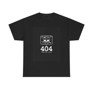 Può includere: Una t-shirt nera a maniche corte con una grafica bianca di una finestra del browser del computer contenente l'icona di un teschio, il numero 404 e il testo Sleep Not Found. Il design è centrato sul petto della t-shirt con scollo rotondo.