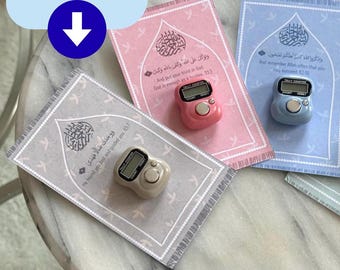 May include: Three prayer mats with Arabic script and digital tally counters. The mats are in pink, blue, and gray, each with a different design and text. The counters are in pink, blue, and beige.