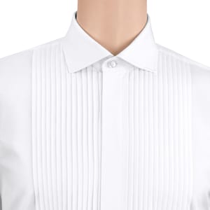 Puede incluir: Primer plano de una camisa blanca con pechera plisada y cuello clásico. La camisa está abotonada en el cuello y presenta pliegues verticales en la parte delantera. La tela parece nítida y limpia.