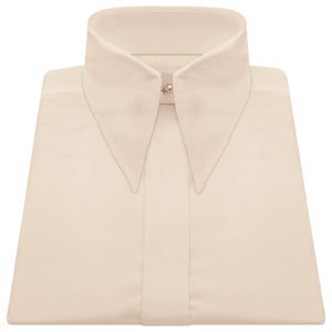 May include: Cream-coloured dress shirt with a high, pointed collar. The shirt is neatly folded, highlighting the collar's design and a small, silver-toned button at the neck. The fabric appears smooth and likely made of a lightweight material.