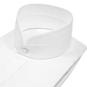 Puede incluir: Primer plano de una camisa blanca con cuello alto y redondeado. El cuello está abotonado en la parte delantera con un pequeño botón redondo. La camisa está hecha de una tela suave y nítida.