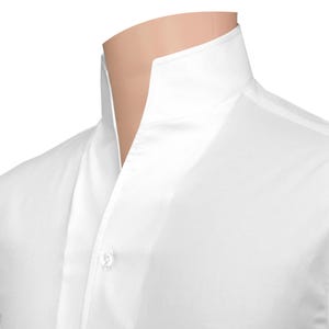 Peut inclure: Gros plan d'une chemise blanche avec un col officier. La chemise est boutonnée au niveau du cou et présente une texture lisse et nette. Le col se dresse autour du cou, créant un look épuré et moderne.