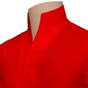 May include: A close-up of a vibrant red shirt featuring a mandarin collar. The shirt has a single button closure and is made of a smooth fabric. The collar stands up around the neck.