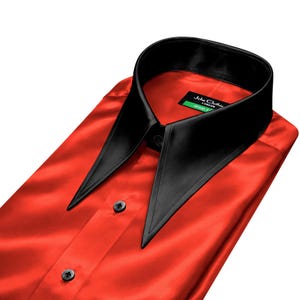 May include: A red satin dress shirt with a black collar and black buttons. The shirt has a pointed collar and a classic button-down design. The label reads "John Clothie London".