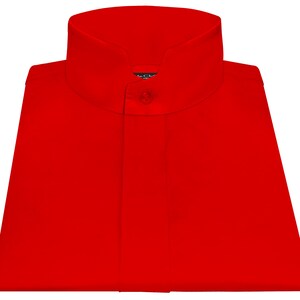 Puede incluir: Una camisa roja brillante con cuello mandarín y cierre de un solo botón. La camisa está cuidadosamente doblada, mostrando su tejido liso y sin arrugas. Un pequeño emblema es visible cerca del cuello.