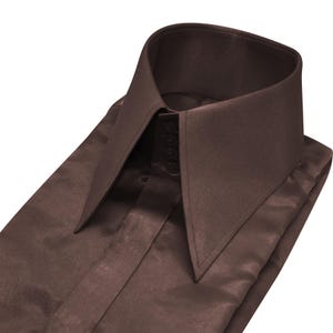 May include: A folded brown dress shirt with a high, pointed collar. The shirt is made of a smooth, satin-like material and features a button-up front. The collar is a prominent design element, adding a touch of sophistication.