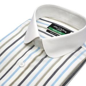 以下が含まれることがあります： 白い襟付きのストライプシャツのクローズアップ。 シャツは、白の背景に青、グレー、ベージュの縦縞模様です。 ラベルには「John Clothier London Green Label 100% Cotton」と書かれています。