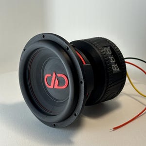 May include: A black subwoofer with a red DD logo and red accents. The subwoofer has a digital display and wires extending from the back. The speaker is designed for car audio systems.