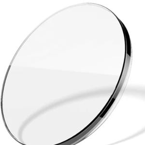 May include: A clear, circular lens with a thin, dark rim. The lens is transparent, allowing light to pass through. The image is set against a white background, highlighting the lens's clarity and shape. This product is likely for eyeglasses or optical equipment.