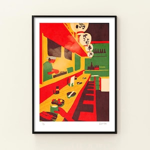 May include: A framed print of a Japanese restaurant interior. The artwork features a red awning, yellow walls, and a green background. A chef is preparing food behind a counter. White lanterns hang from the ceiling, and food is served on the counter.