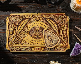 May include: A wooden Ouija board with a planchette featuring a skull and crossbones design. The board has a traditional layout with letters, numbers, and the words "yes", "no", and "goodbye".